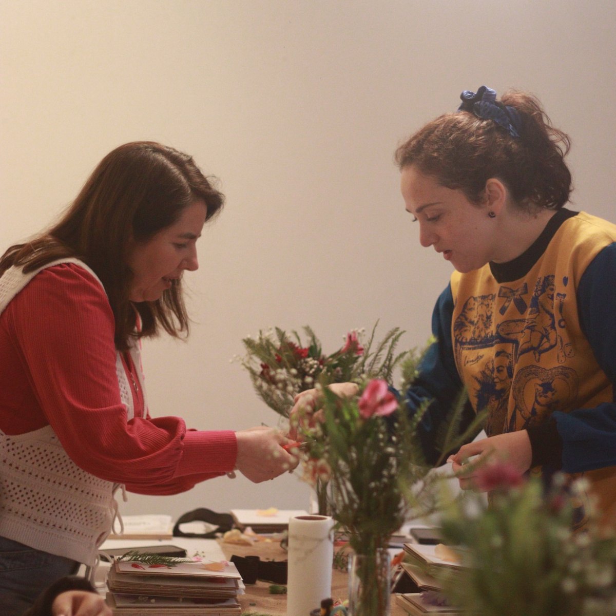 Participantes seleccionando flores frescas durante el taller de prensado floral