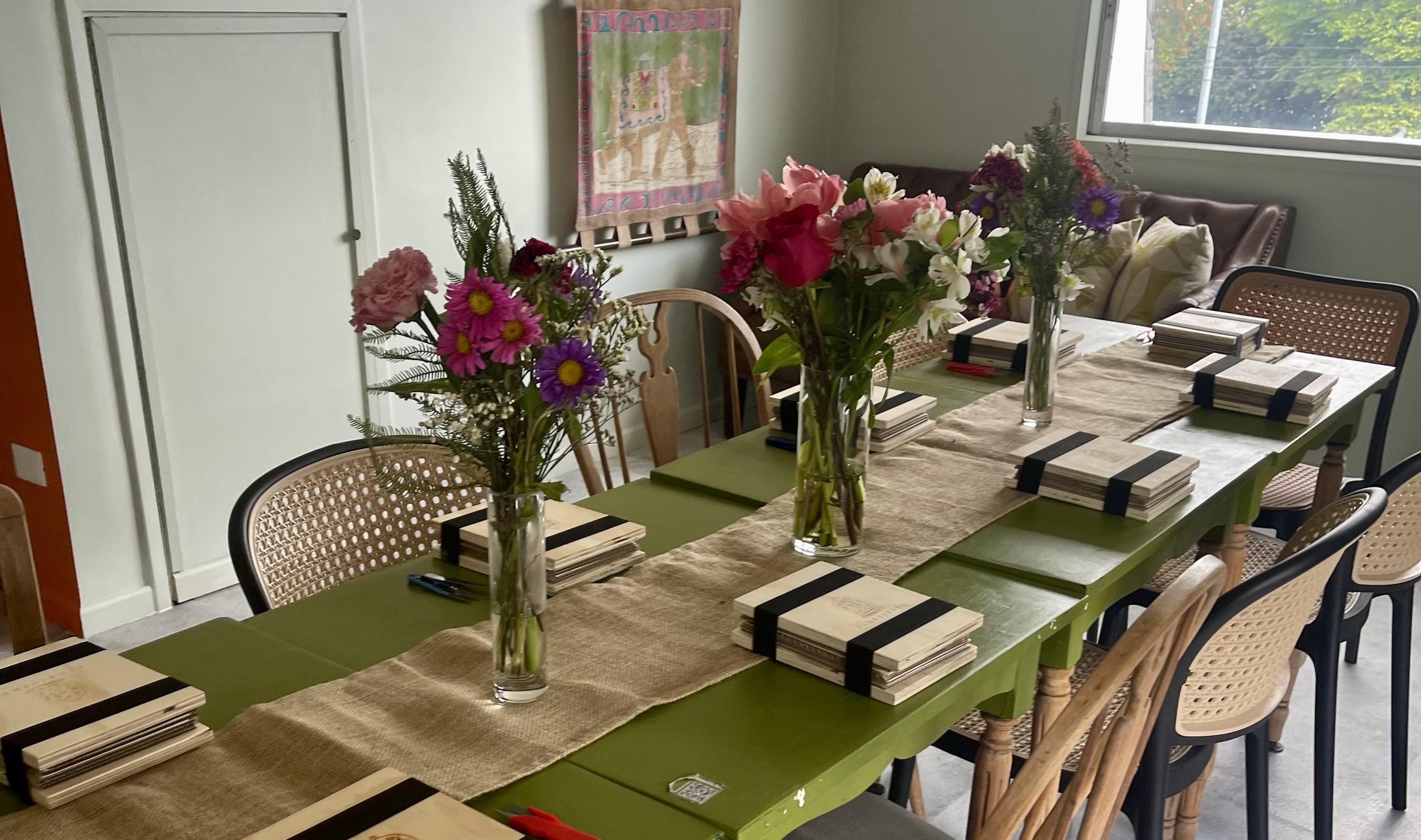 Personas trabajando con flores alrededor de una mesa en un taller de Floriverso